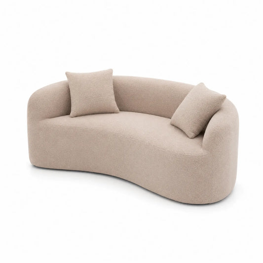 Sofá curvo de tela bouclé beige con cojines